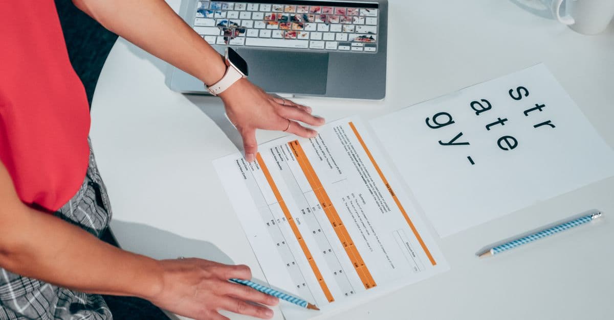 An overhead view of a desk with a laptop and printed documents laid out, the kind of planning work a team does before mapping data for a software migration.