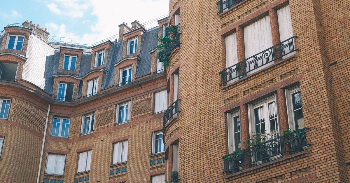 A modest multi-story brick apartment building with balconies, the kind of ordinary mid-market rental housing workforce programs serve.